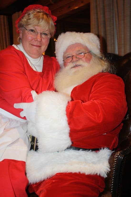 Mrs. Clause sits on Santa's lap for a picture at the end of the evening.