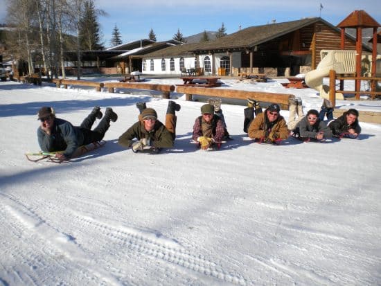 the men pose before taking off on their sleds