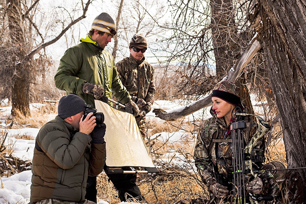 Carly in full camo with a bow, poses for the film and photo crew at Dick's.