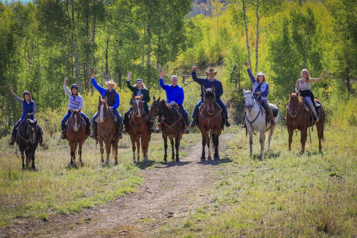 team building group waving on horses