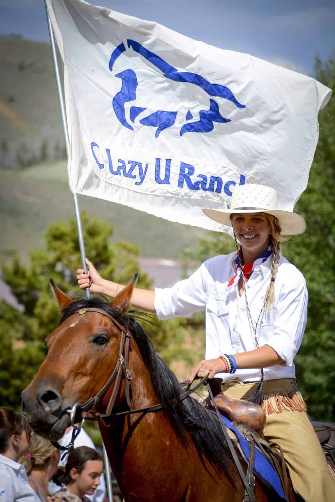 c lazy u ranch girl holding flag on horse