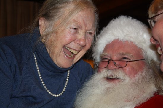 Marjorie Kade, long time guest, laughs with Santa