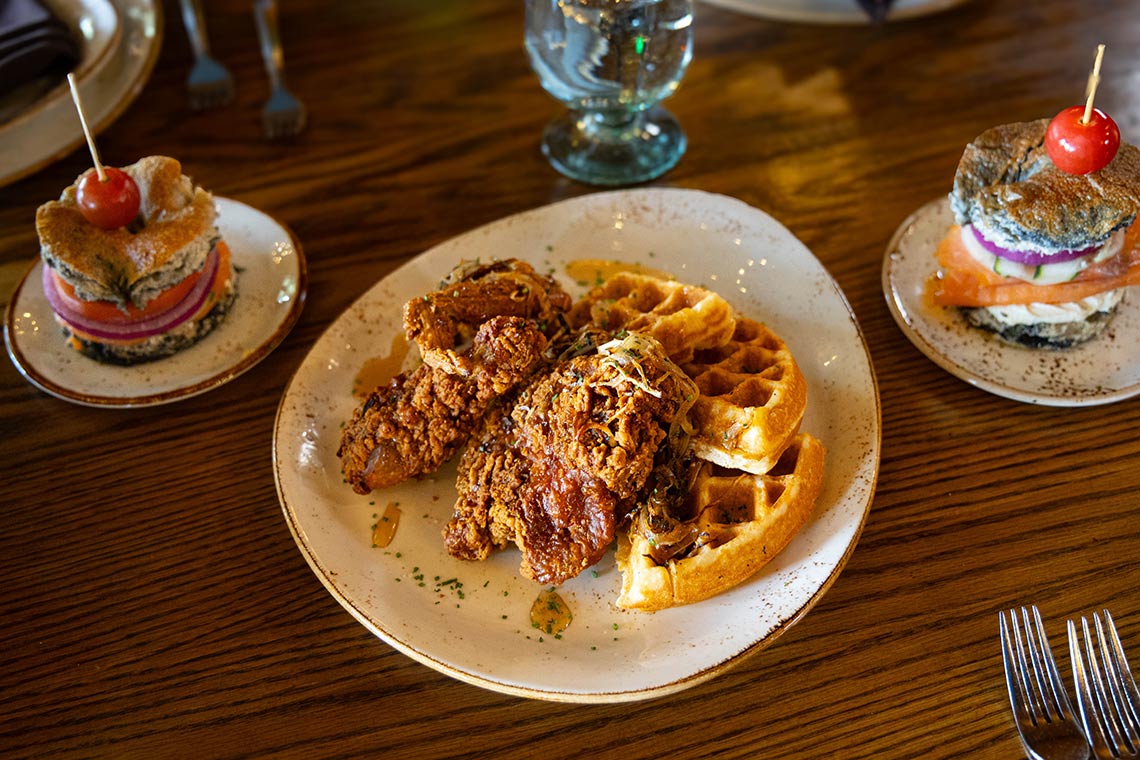 Table setting with Deep fried chicken on waffles and mini sandwiches as appetizers.