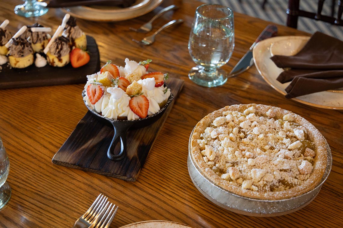 Various desserts set out on a wooden table for consumption