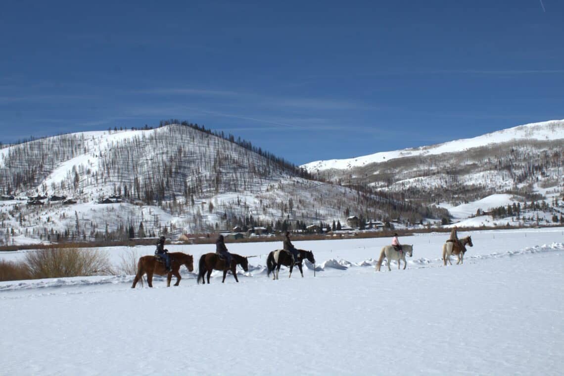 horseback riding in snowy mountains