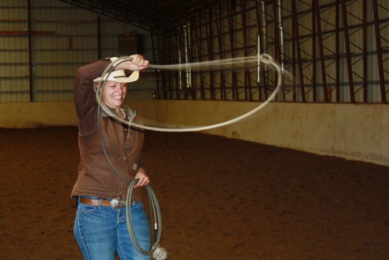 One of our brown shirts (wranglers), Tami, practicing her roping swing in the C Lazy U Ranch indoor arena