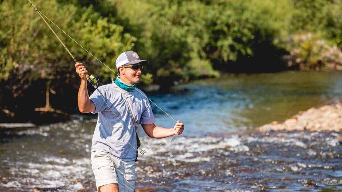 man casting line in river