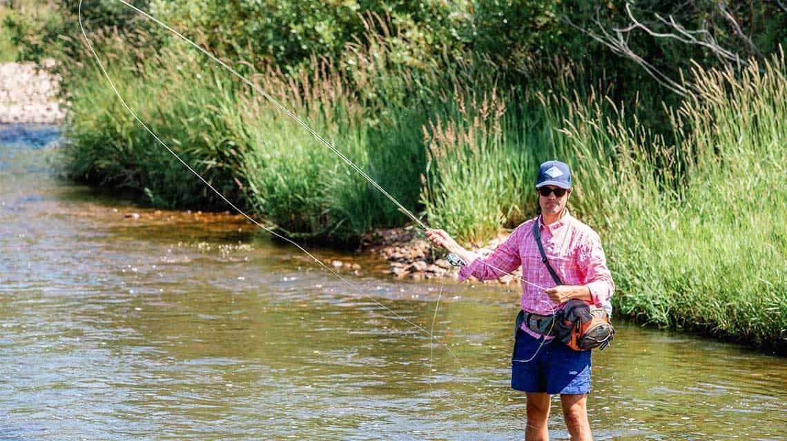 Knee deep in water, fly casting