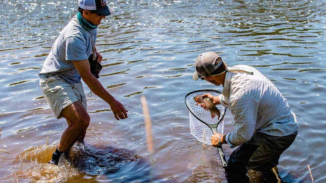 Examining the fish he just caught