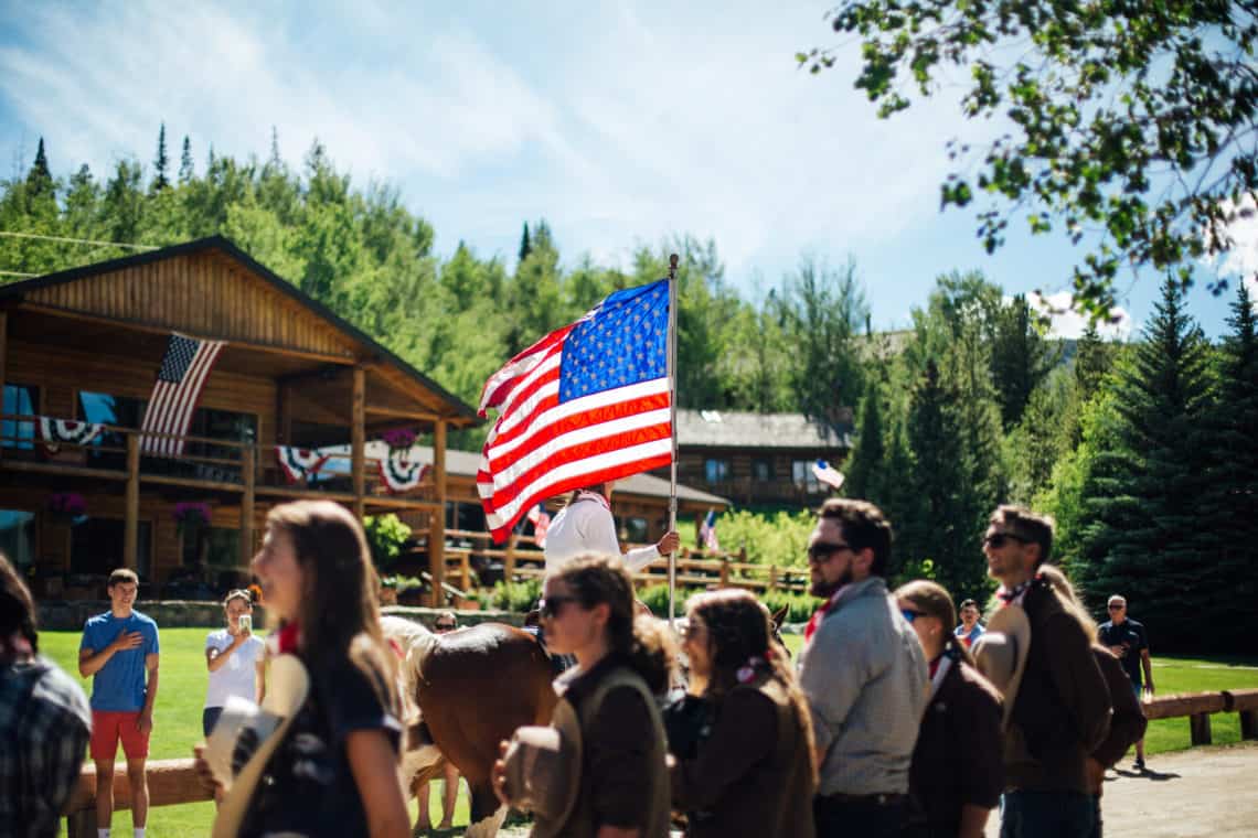 big group celebrating 4th of july with flag 