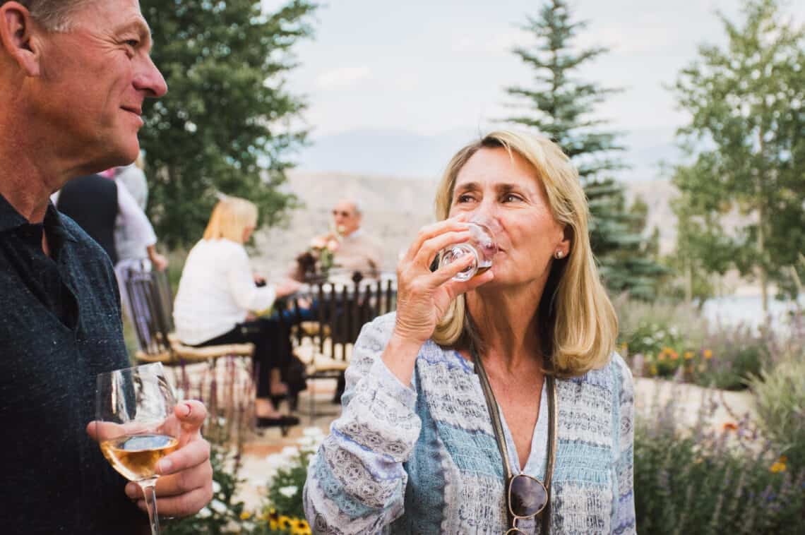 Man and woman sip Lock + Co whiskey at a collaborative event at C Lazy U Ranch in Granby