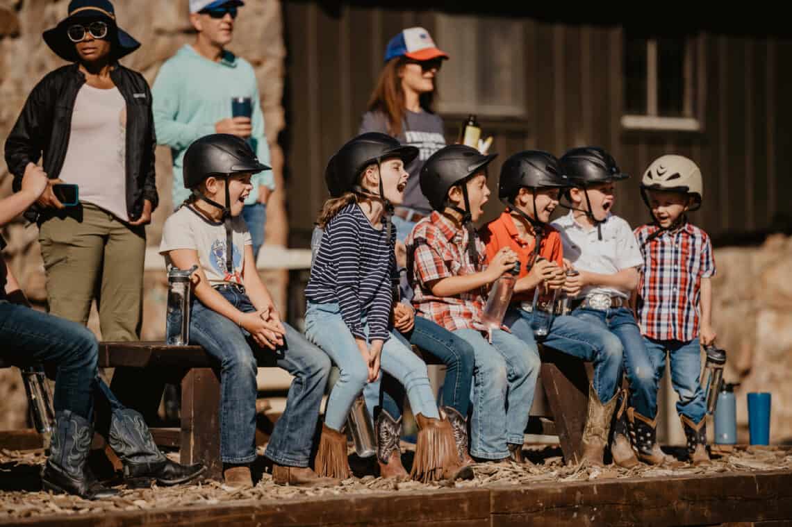 Kids with equestrian helmets have fun at C Lazy U Ranch