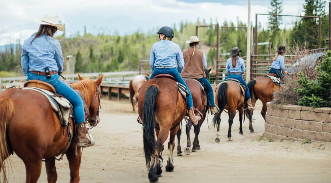 Adults heading out for a trail ride at C Lazy U Ranch