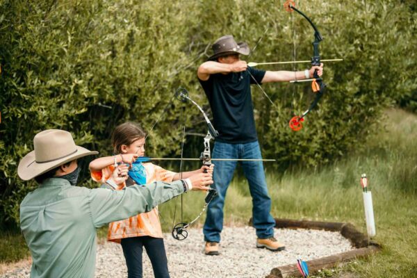 A father and daughter enjoy archery at the ranch