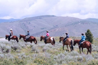 After some practice, everyone is off to the range to start some real horseback riding against the backdrop of the Colorado mountains.
