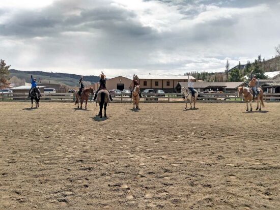 A group horseback riding session in the arena at the C Lazy U Ranch in Granby, Colorado