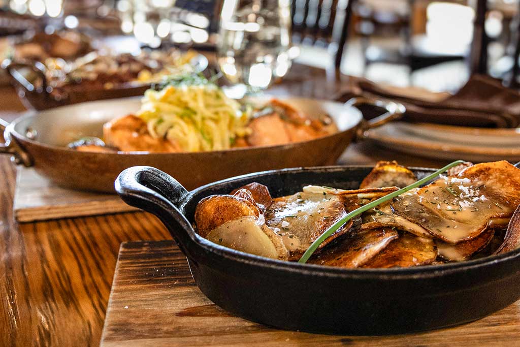 Gourmet ranch dinner at C Lazy U with roasted potatoes in cast iron skillet and pasta dishes