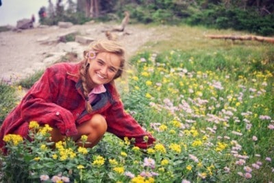 Anna Taylor posing by flowers