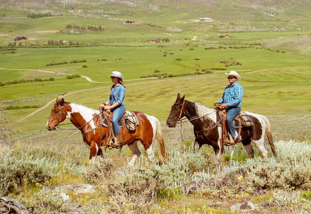 Couple riding horses at C Lazy U