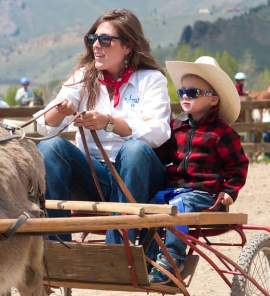 A wee guest enjoys a donkey cart ride during his family's spring vacation at C Lazy U