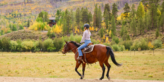 A woman on horseback in fall at C Lazy U