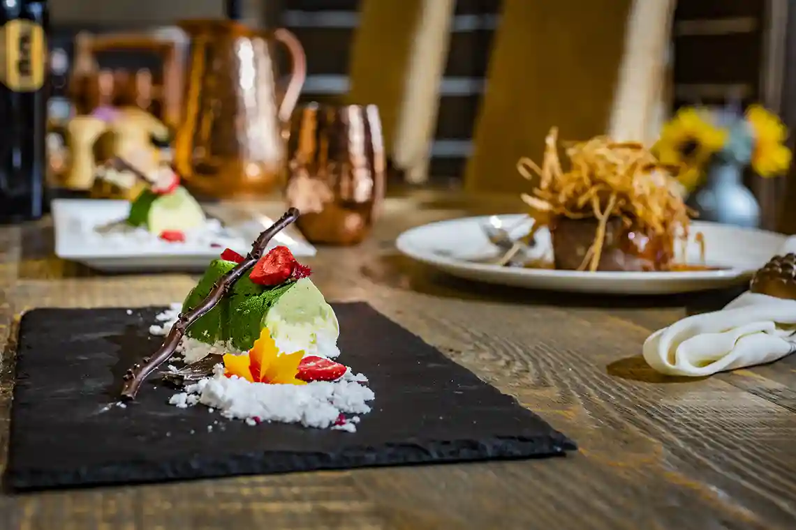 Table set with copper utensils and gourmet food on the plates