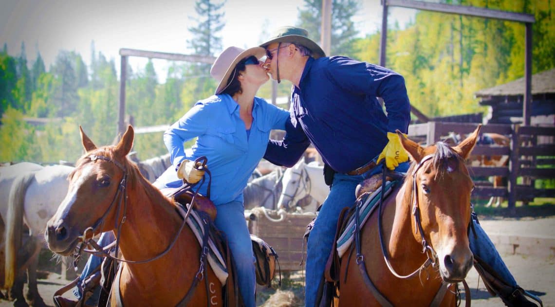 couple kissing on horses