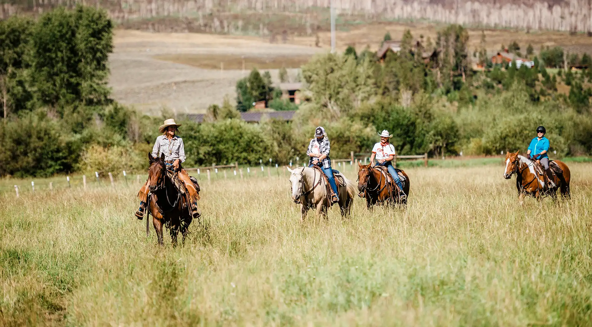 four adults out on a horseback trail ride