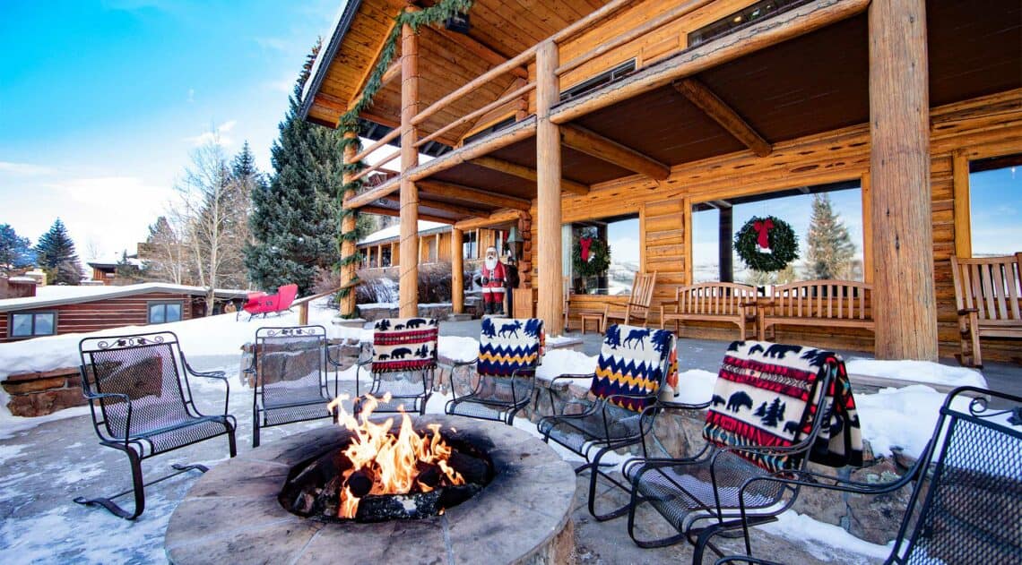 The main lodge decorated for Christmas, with a blazing fire in the outdoor lounge