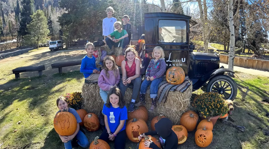 The Fall Kid's Club poses for a group photo with their carved pumpkins