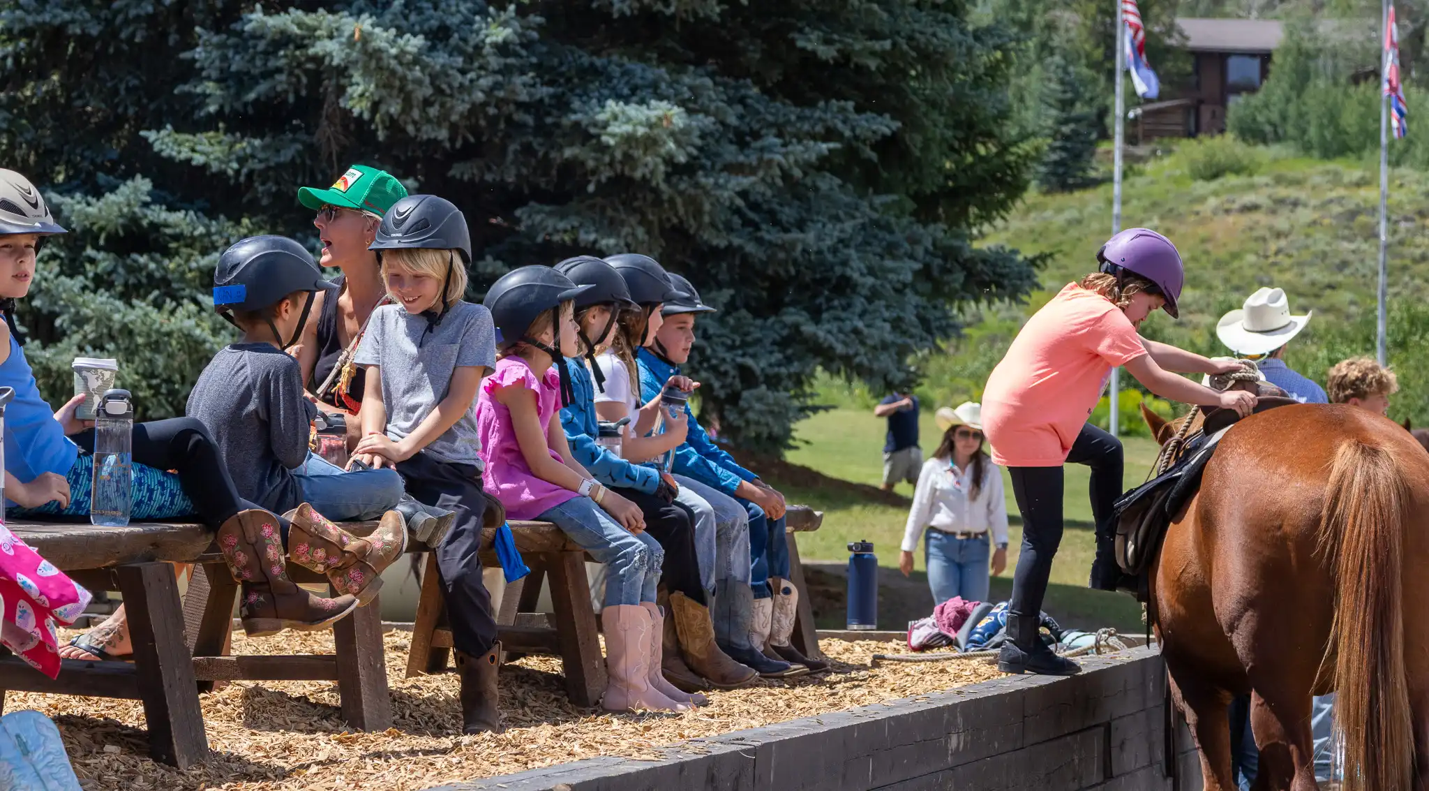 Kids line up at the mounting block for a trail ride