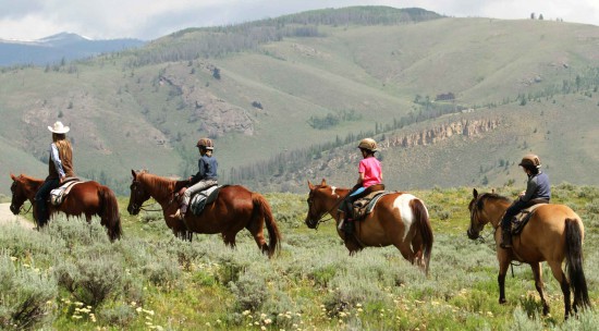 Kids out on a trail ride in the mountains during their vacation at C Lazy U in Colorado