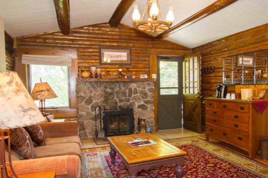 Warm up by the fireplace after a long day on your winter vacation in Colorado. Nearly all of our cabins have one.