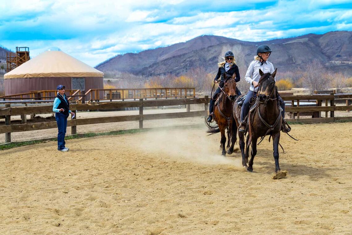 women work their horses in the arena
