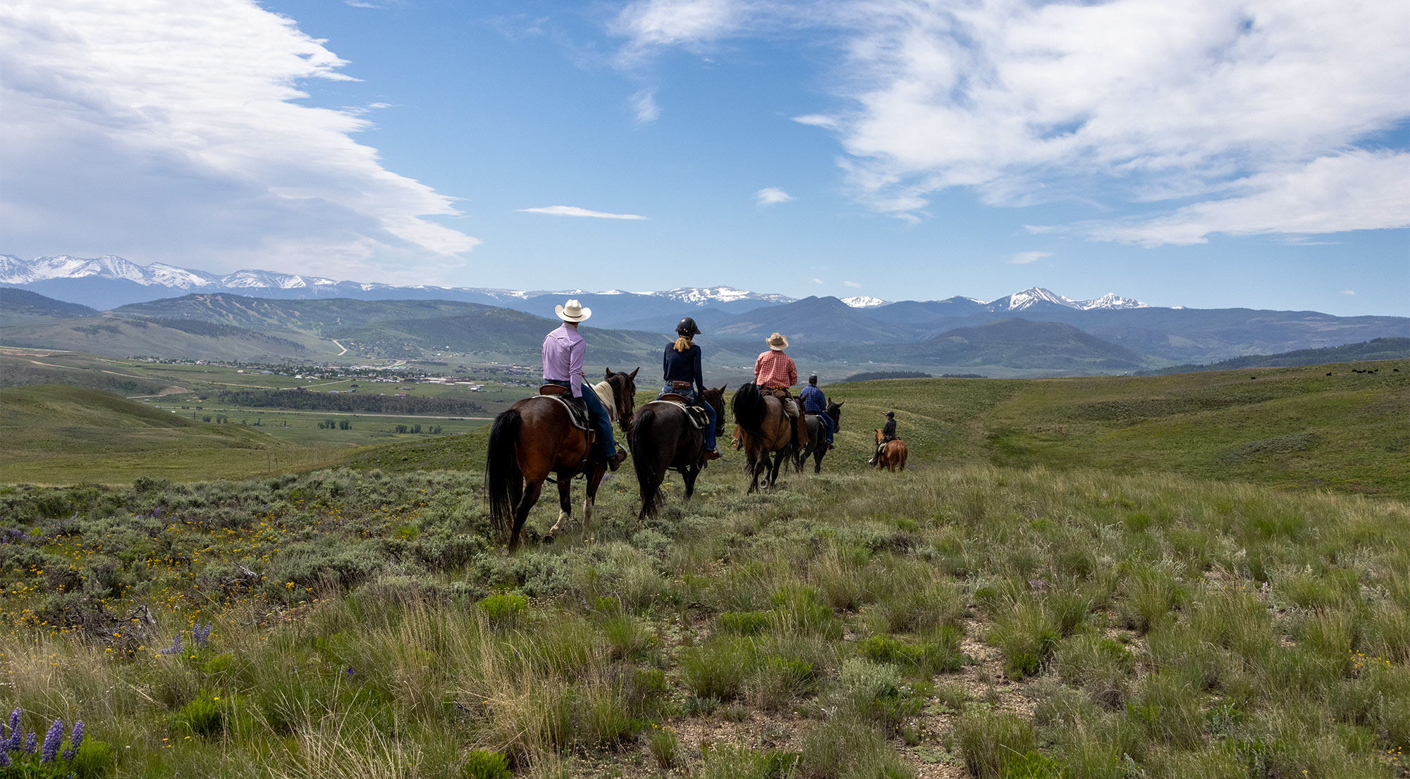 adults riding horses on C Lazy U's vast acreage