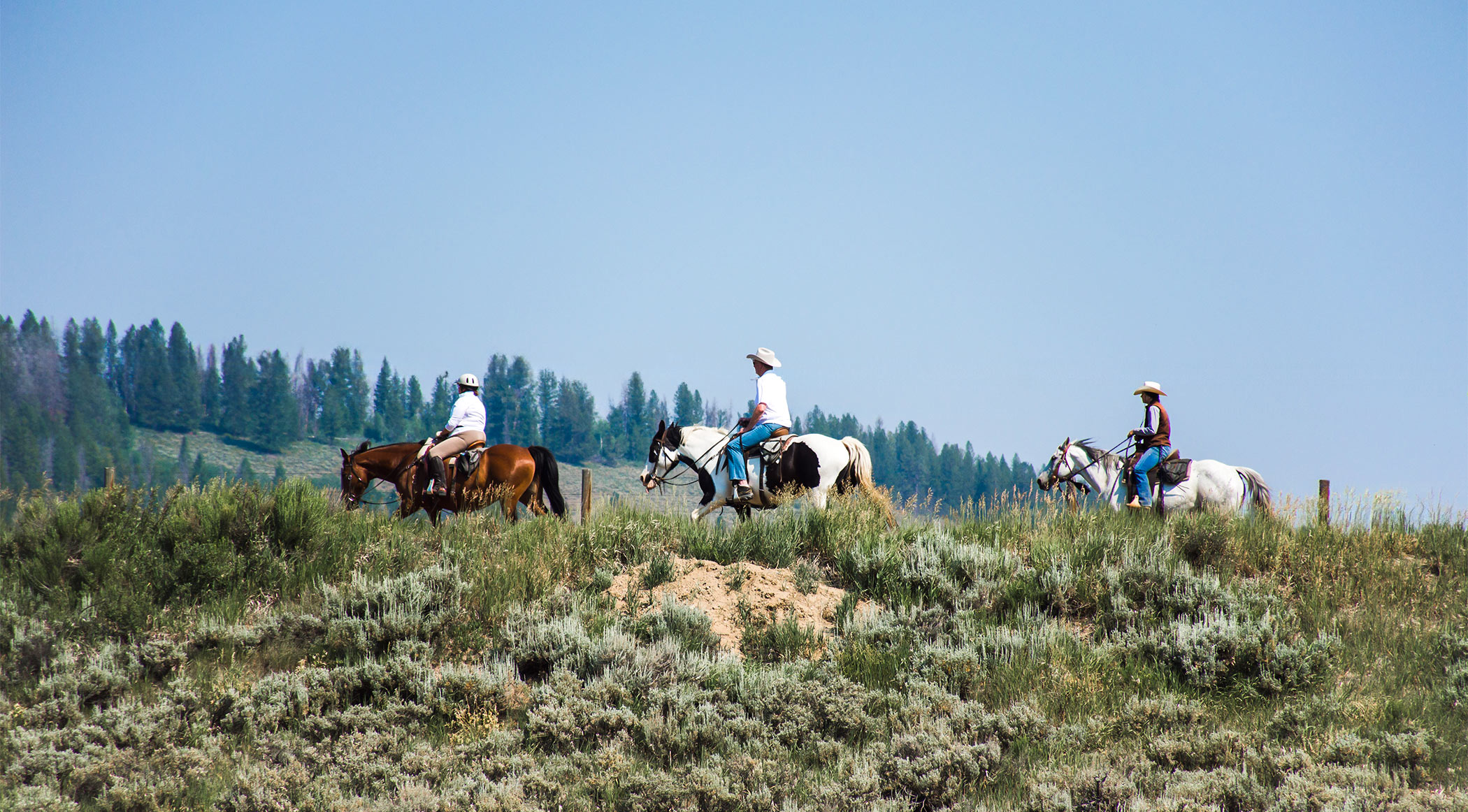 three adults riding out on the trails at C Lazy U