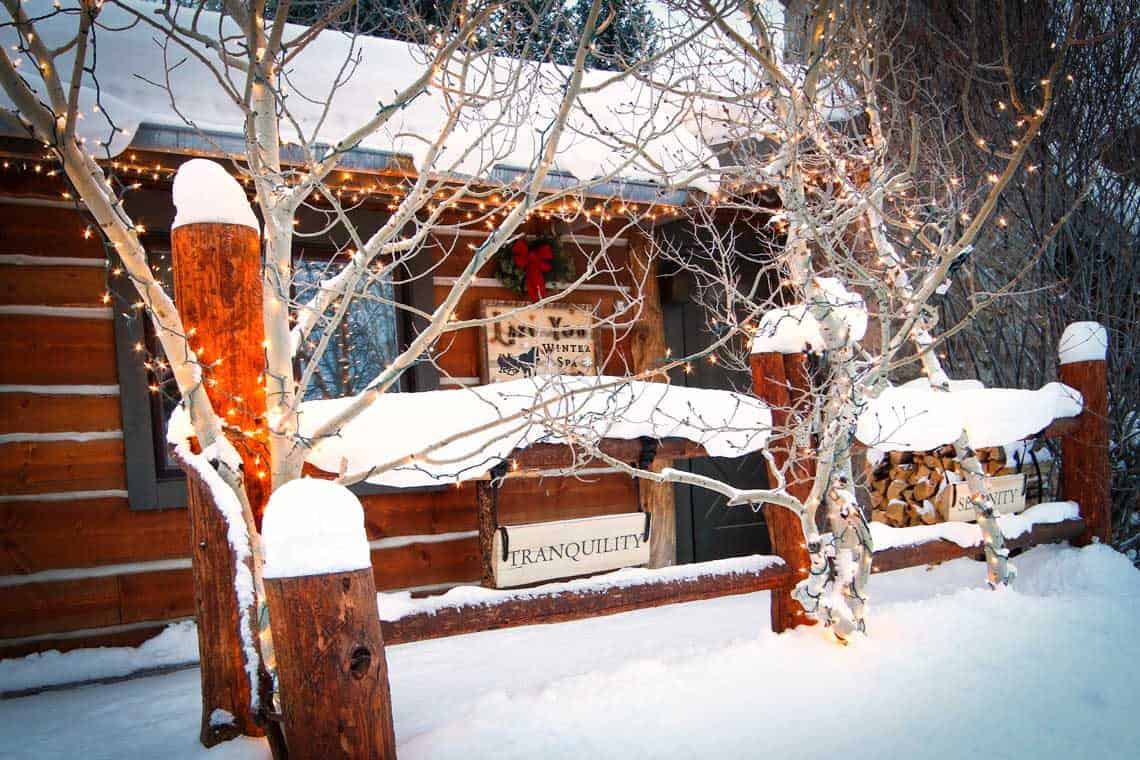 The exterior of Lazy You Spa is covered with snow and decorated with twinkle lights and winter wreaths