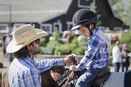 The kids eagerly listen to the pre-ride instructions before beginning their horseback riding vacations.