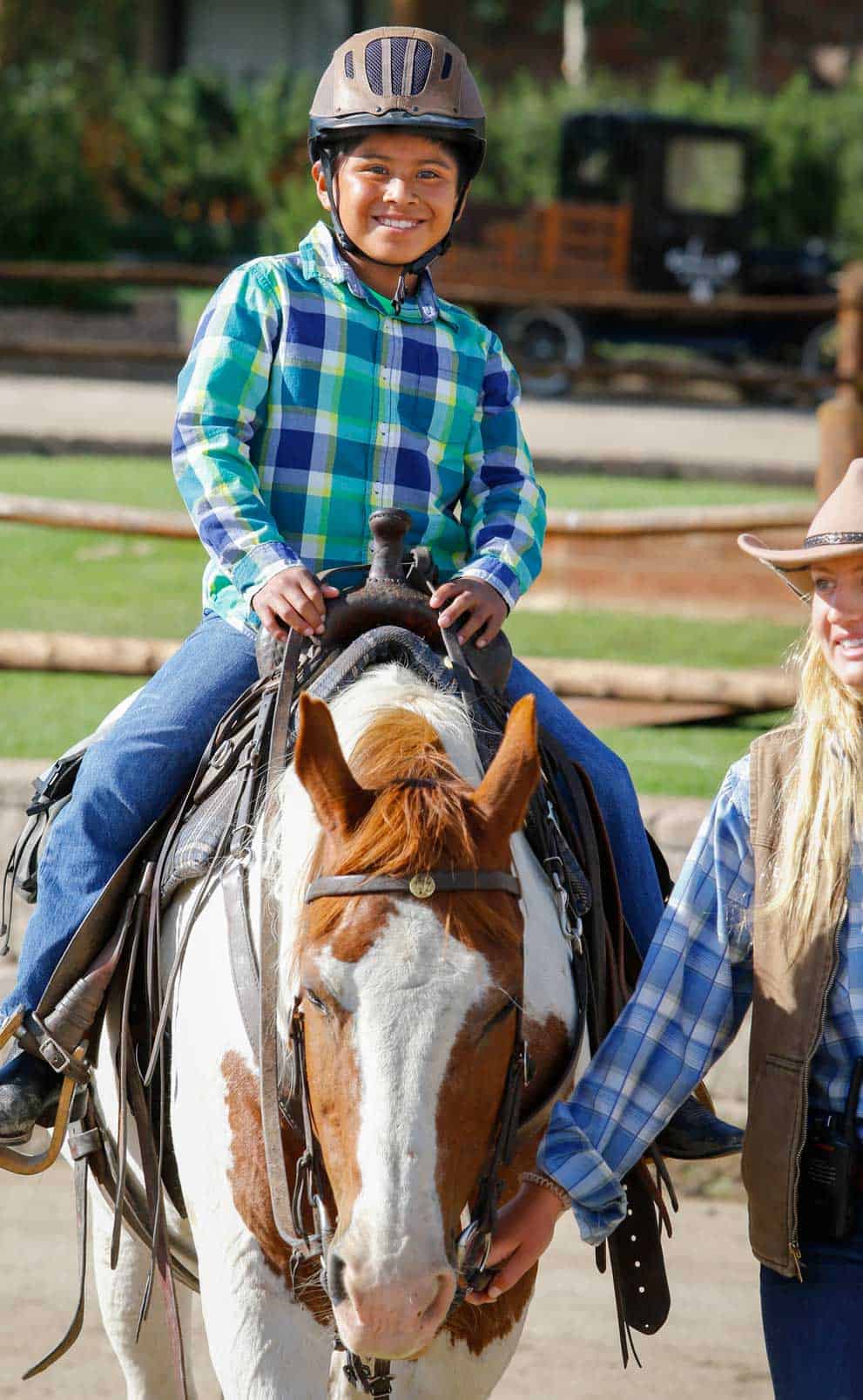 A young boy grins from ear to ear during his pony ride